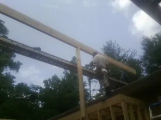Carpenter setting a ridge beam over a new addition frame — Ice Dam Removal by Roofing Brothers in Morrisville