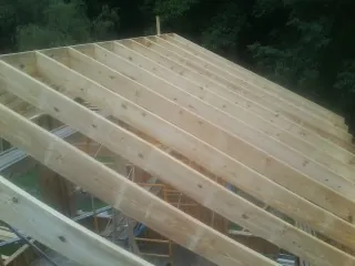 New roof rafters set over an addition before sheathing in Morrisville