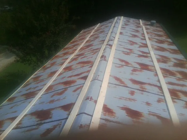 Rusted metal roof panels with new wood purlins before replacement — Storm Damage Roof Repair in Morrisville by Roofing Brothers