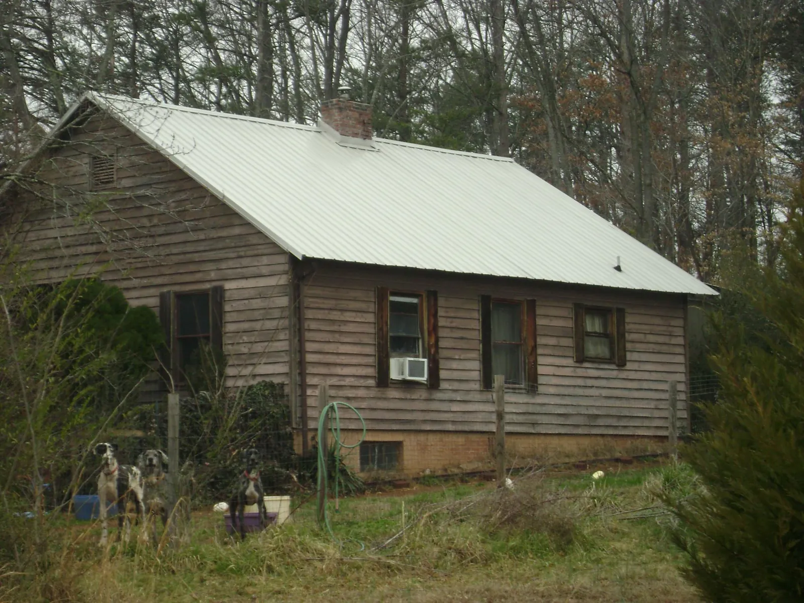 White metal roof on an old wood sided farmhouse, from a Metal Roof Installation job in Morrisville